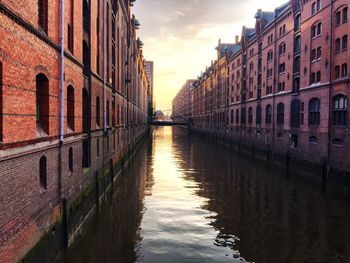 Canal amidst buildings against sky