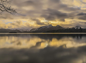 Scenic view of lake by mountains against sky