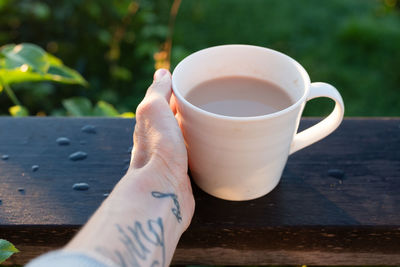 Close-up of hand holding coffee cup