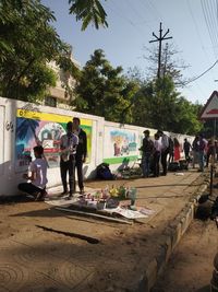 People on street in city against sky