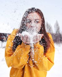 Close-up of woman blowing snow