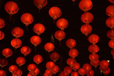 Low angle view of illuminated paper lanterns hanging against sky at night