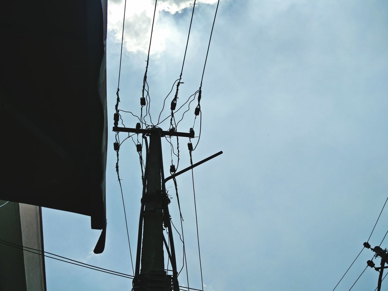 low angle view, sky, built structure, crane - construction machinery, fuel and power generation, industry, architecture, development, technology, construction site, crane, tall - high, construction, building exterior, no people, outdoors, day, electricity, smoke stack, electricity pylon