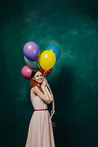 Rear view of young woman holding balloons