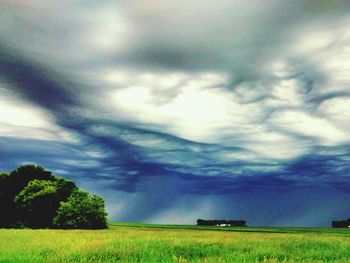 Scenic view of field against cloudy sky