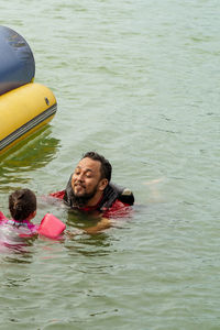 High angle view of siblings swimming in lake