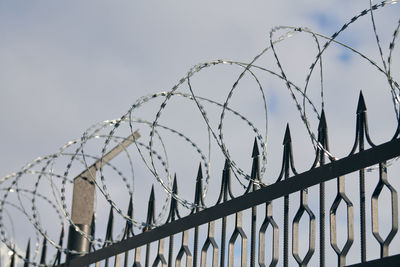 Barbed wire on fence, steel grating fence, metal fence wire. coiled razor wire with steel barbs