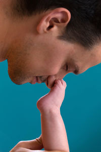 Close-up portrait of boy against blue background