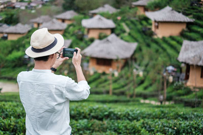 Full length of man photographing with mobile phone