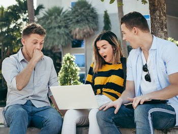 Smiling friends studying together at university campus