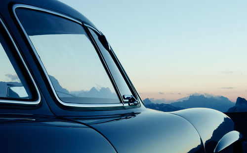 Close-up of reflection on side-view mirror against sky