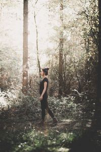 Rear view of man standing in forest