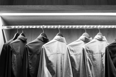 Black and white picture.cloth hangers with shirts.