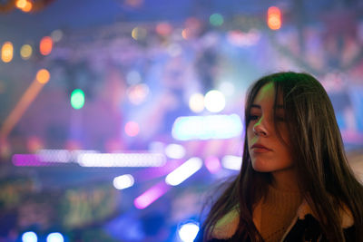 Portrait of woman with illuminated lights at night