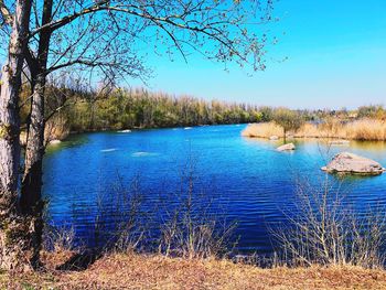 Scenic view of lake against clear blue sky