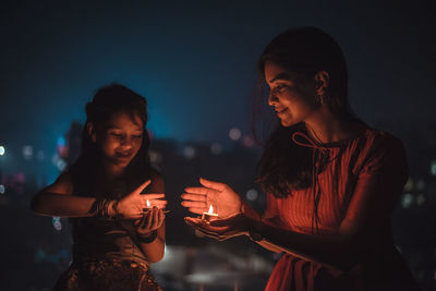 Young man and woman standing at night