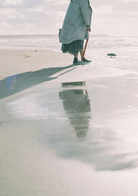 Low section of woman walking on beach