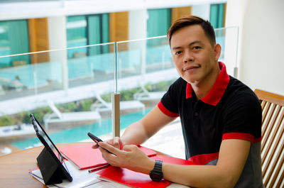 Portrait of young man using digital tablet in office