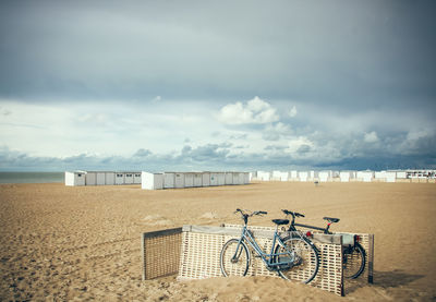 Bicycle on beach against sky