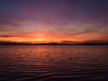 Scenic view of sea against dramatic sky during sunset