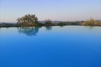 Scenic view of lake against clear blue sky
