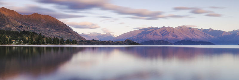 Scenic view of lake by mountains against sky