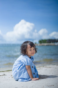 Portrait of baby girl at beach under the blue sky