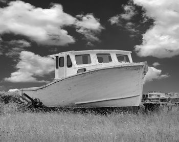 Abandoned ship on field against sky