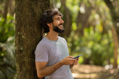 Young man at park on a beautiful sunny day with mobile phone.  working  leisure. green and nature 