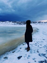 Rear view of a man on snow covered beach