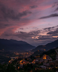 Illuminated cityscape against sky at sunset