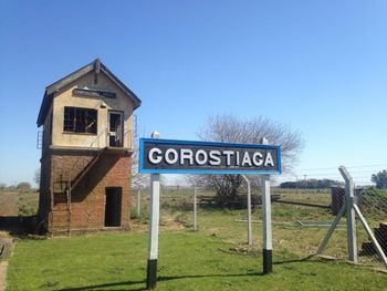 Information sign against clear blue sky