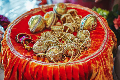 High angle view of jewelries on orange textile