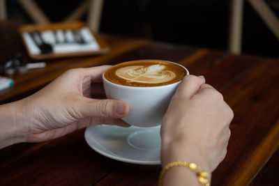 Midsection of woman holding coffee cup