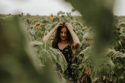 Young woman standing at sunflower farm