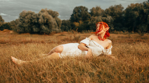 Young woman sitting on grassy field