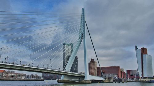 Bridge over river against cloudy sky