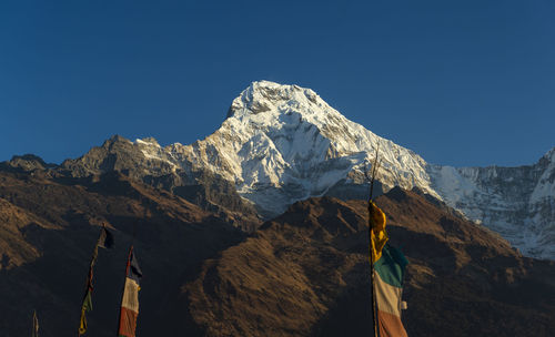 Scenic view of snowcapped mountains against clear blue sky