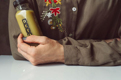 Midsection of woman holding hands on table