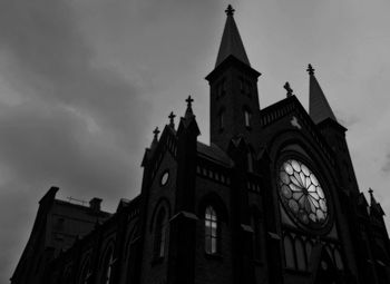 Low angle view of clock tower against cloudy sky