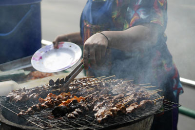 Man preparing food on barbecue grill