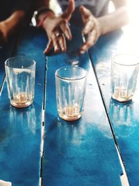 Midsection of people in glass on table