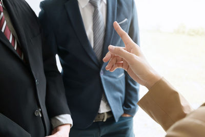 Midsection of man standing in front of two people