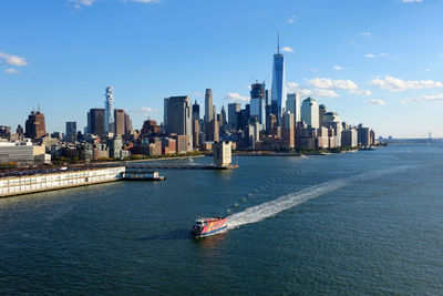 View of boats in river with city in background