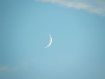 Low angle view of moon against blue sky