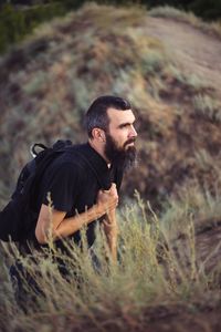 Portrait of a man with a tourist backpack with a beard on the background of nature and mountains