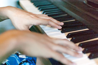 Midsection of person playing piano