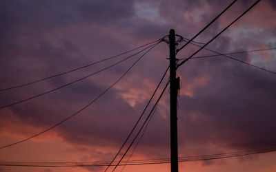 Electricity pylon against sky at sunset