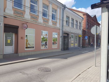 Buildings by street against sky