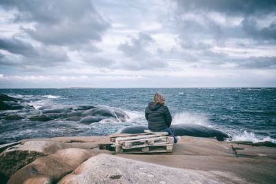 Rear view of man sitting on beach